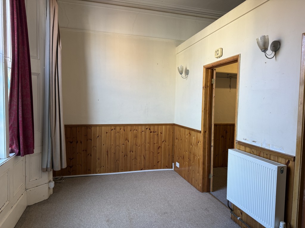 Lot: 156 - VACANT GROUND-FLOOR STUDIO FLAT WITH INVESTMENT POTENTIAL - Living room area with wooden wall panels